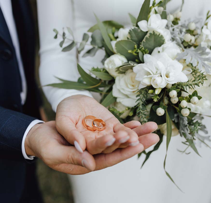 Una mano de un hombre y una mujer sosteniendo unos anillos