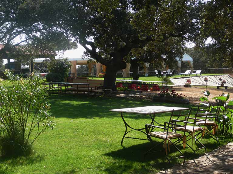 Jardín de las Ahijaderas con mesas y un carpa para comer