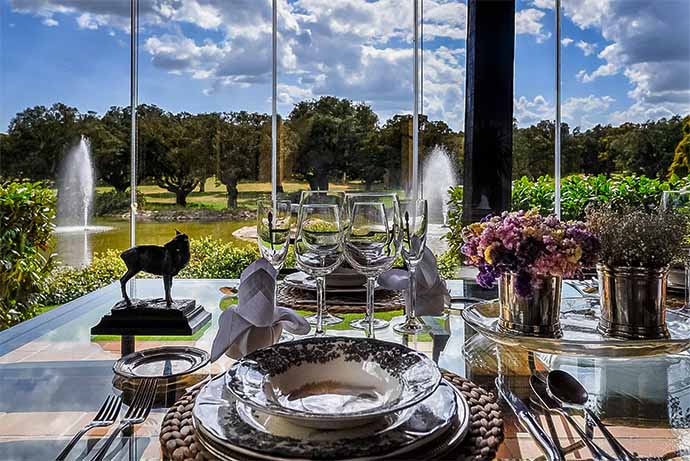 Mesa con la cubertería puesta lista para comer en una de las casas de las Ahijaderas, con vistas a un lago