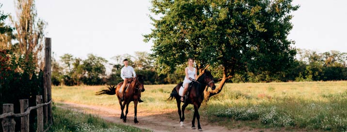 Chico y chica montando a caballo