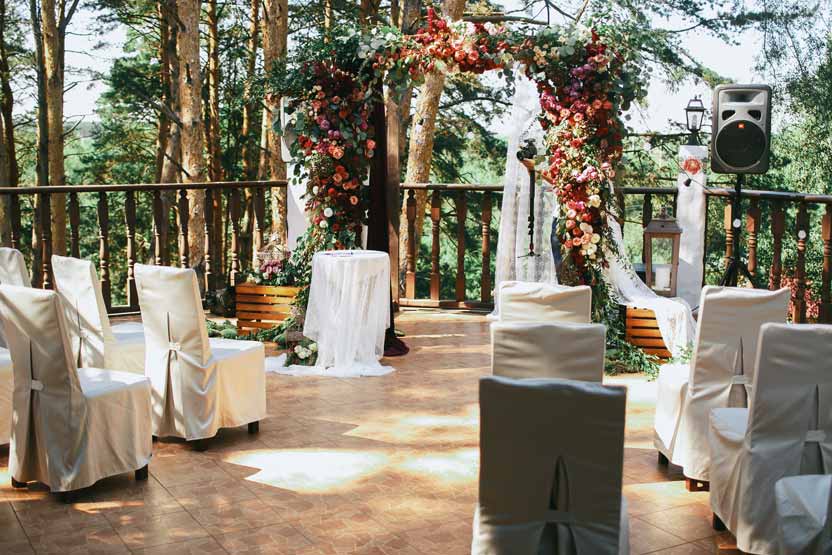 sillas blancas dispuestas frente a un altar de boda.