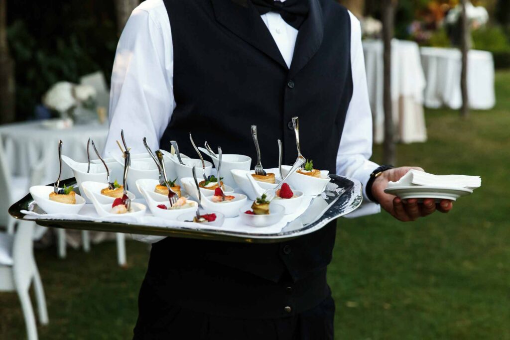 Camarero llevando tapas en una bandeja en evento