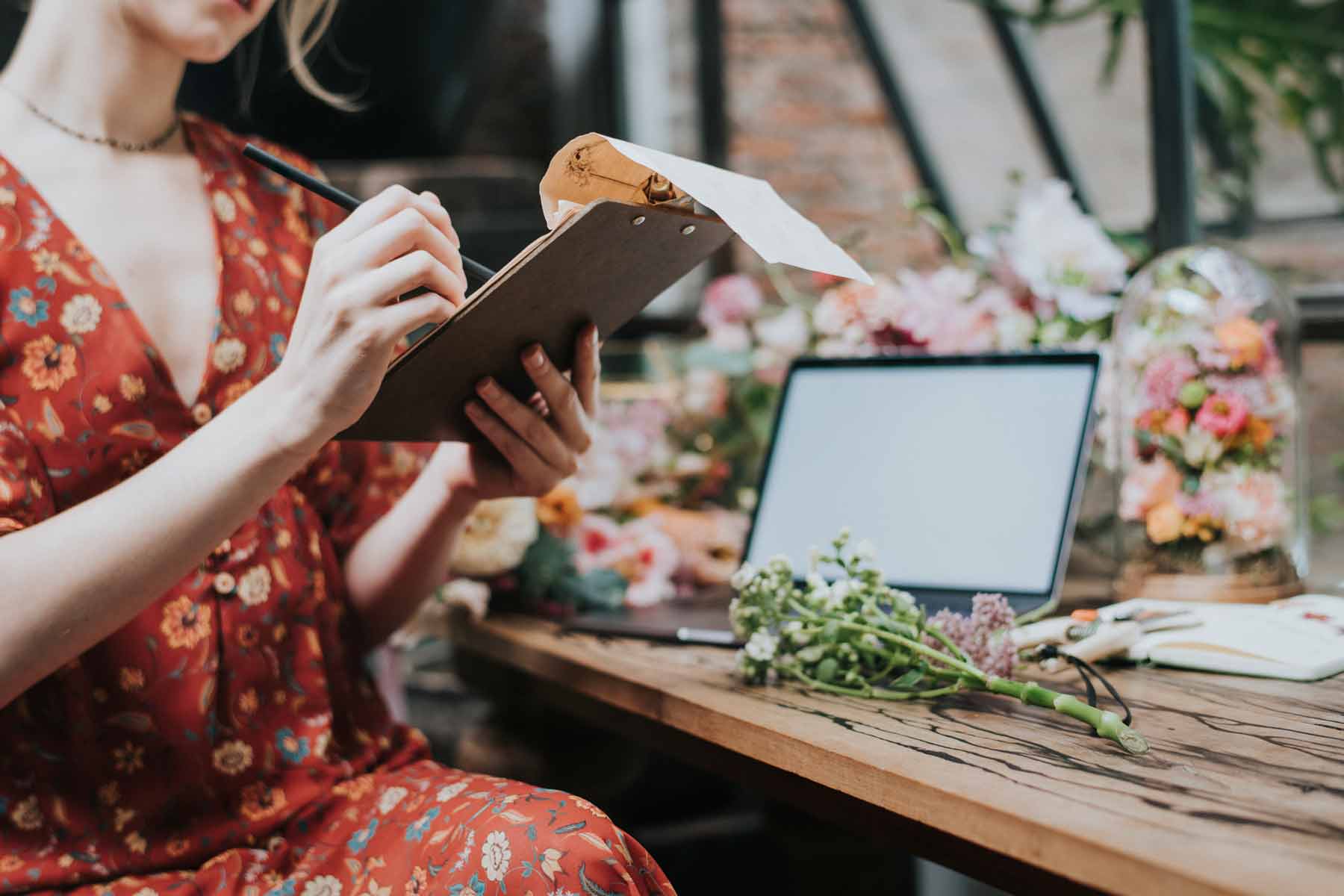 Florista con una libreta organizando sus pedidos